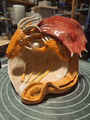 Kunstvolle Keramikfigur eines Tieres mit bunten Details und organischen Formen.